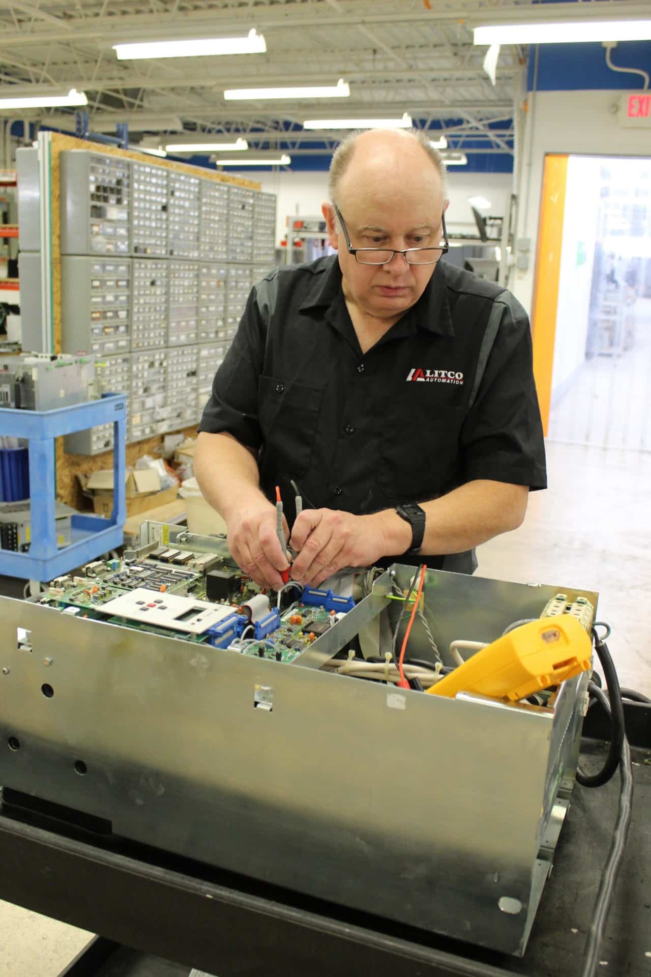 Litco Automation technician checking an open drive assembly with test probes