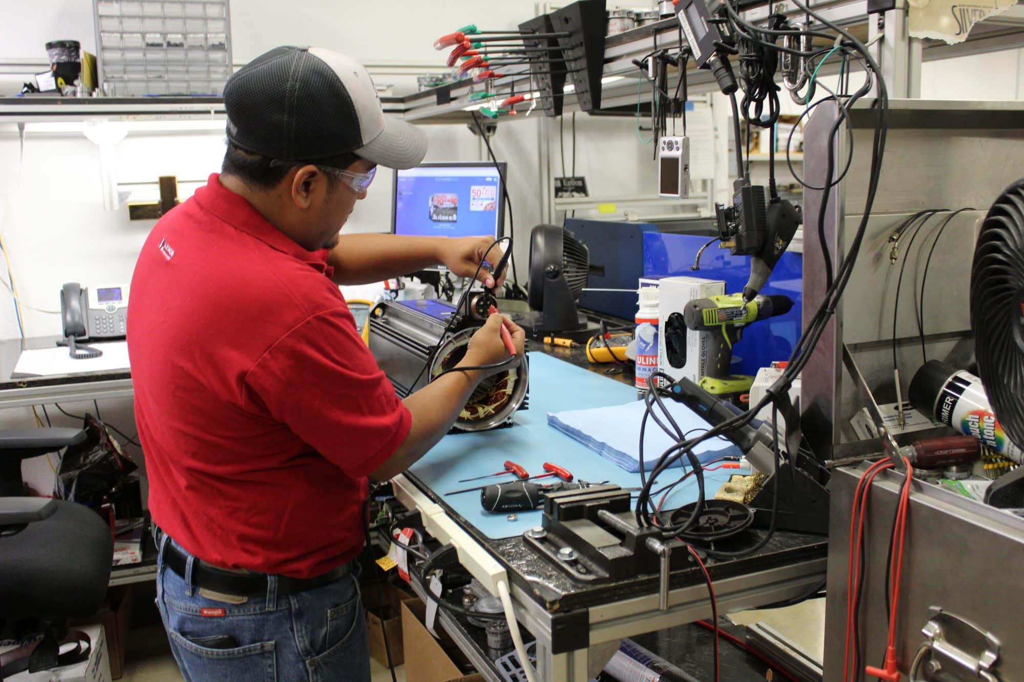 Litco technician checking a disassembled servo motor at a workshop bench